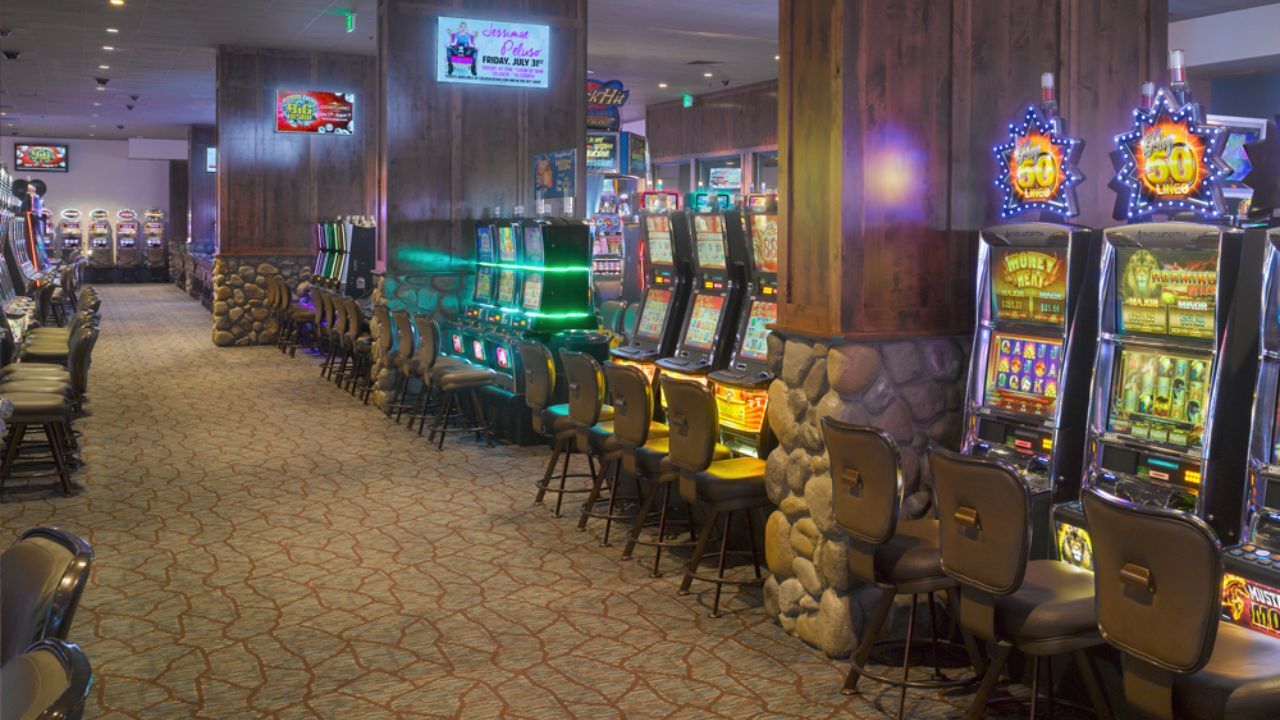 Casino floor featuring slot machines and empty chairs